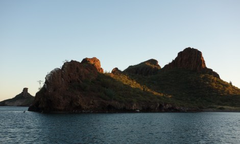 The other, undeveloped side of the bay, seen from our boat. We love watching the pelicans hunt along the base of the rock, and every morning a family of three ospreys calls back and forth to each other across the water.